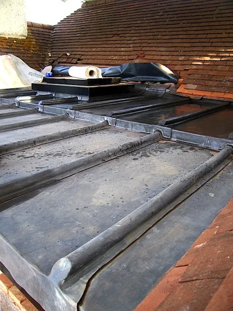 New lead sheets with rolled joints being laid on a roof