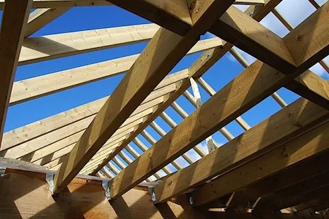 The new timber roof structure for an extension, seen from below against the sky